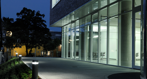 Beleuchtetes Bürogebäude bei Nacht von außen fotografiert